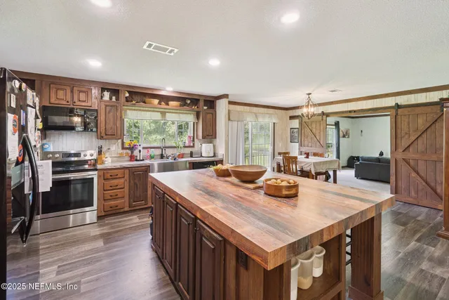 a kitchen with kitchen island a stove a sink and a refrigerator