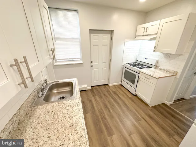 a kitchen with a stove a sink and a refrigerator