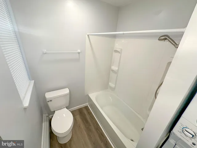 a white toilet sitting next to a shower