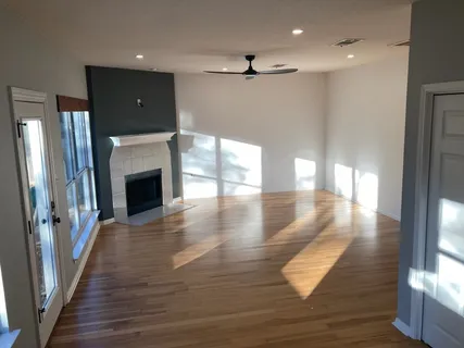 a view of a hallway with wooden floor and a fireplace