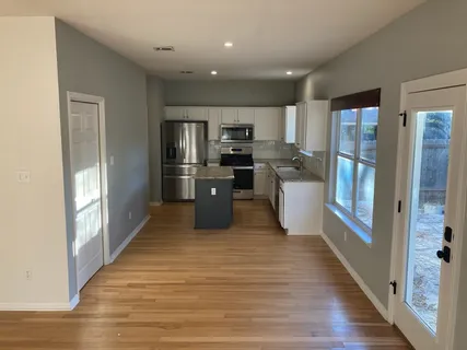 a kitchen with stainless steel appliances granite countertop a refrigerator and a stove top oven
