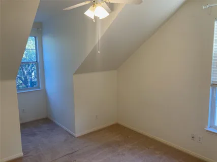 an empty room with a chandelier fan