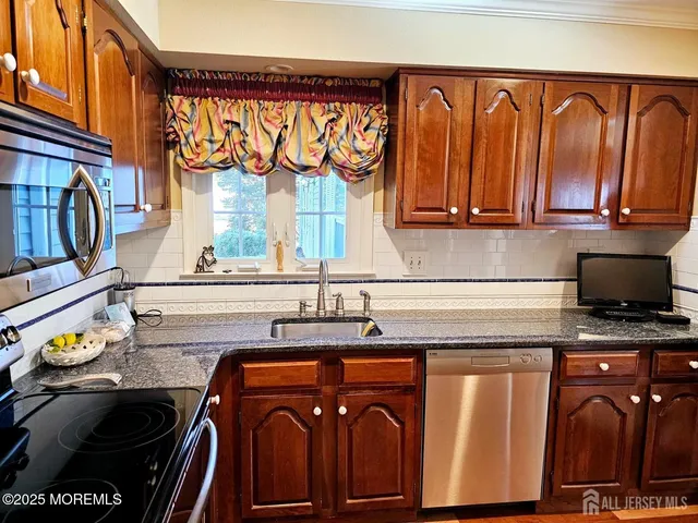 a kitchen with stainless steel appliances granite countertop a stove and a microwave