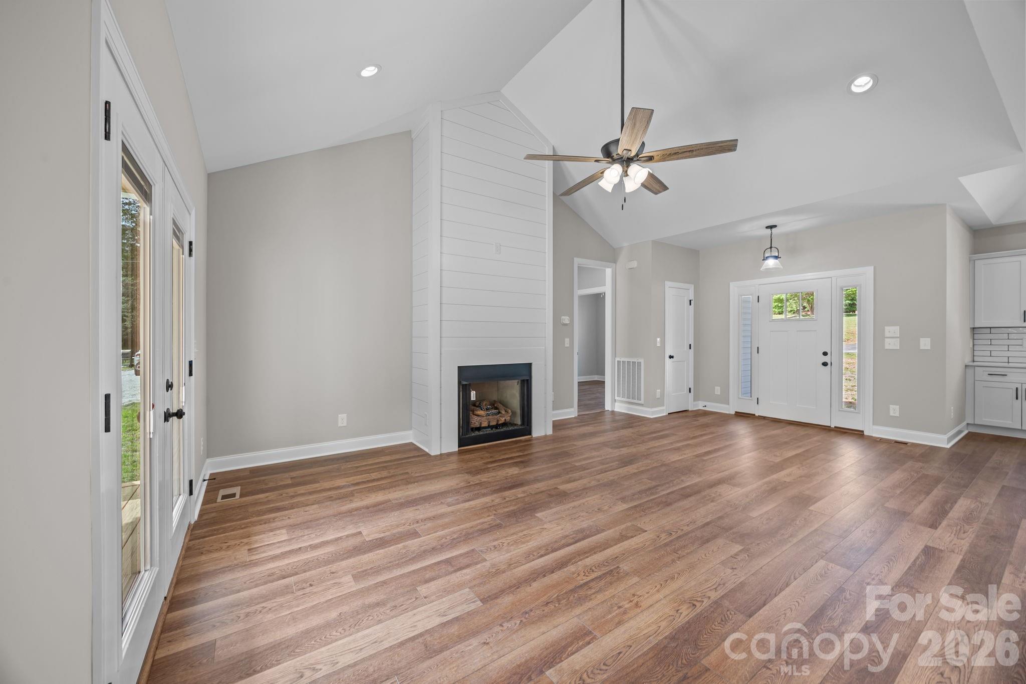 5037 Faith Road Salisbury, NC 28146 - Photo 11 of 45 an empty room with wooden floor ceiling fan and windows