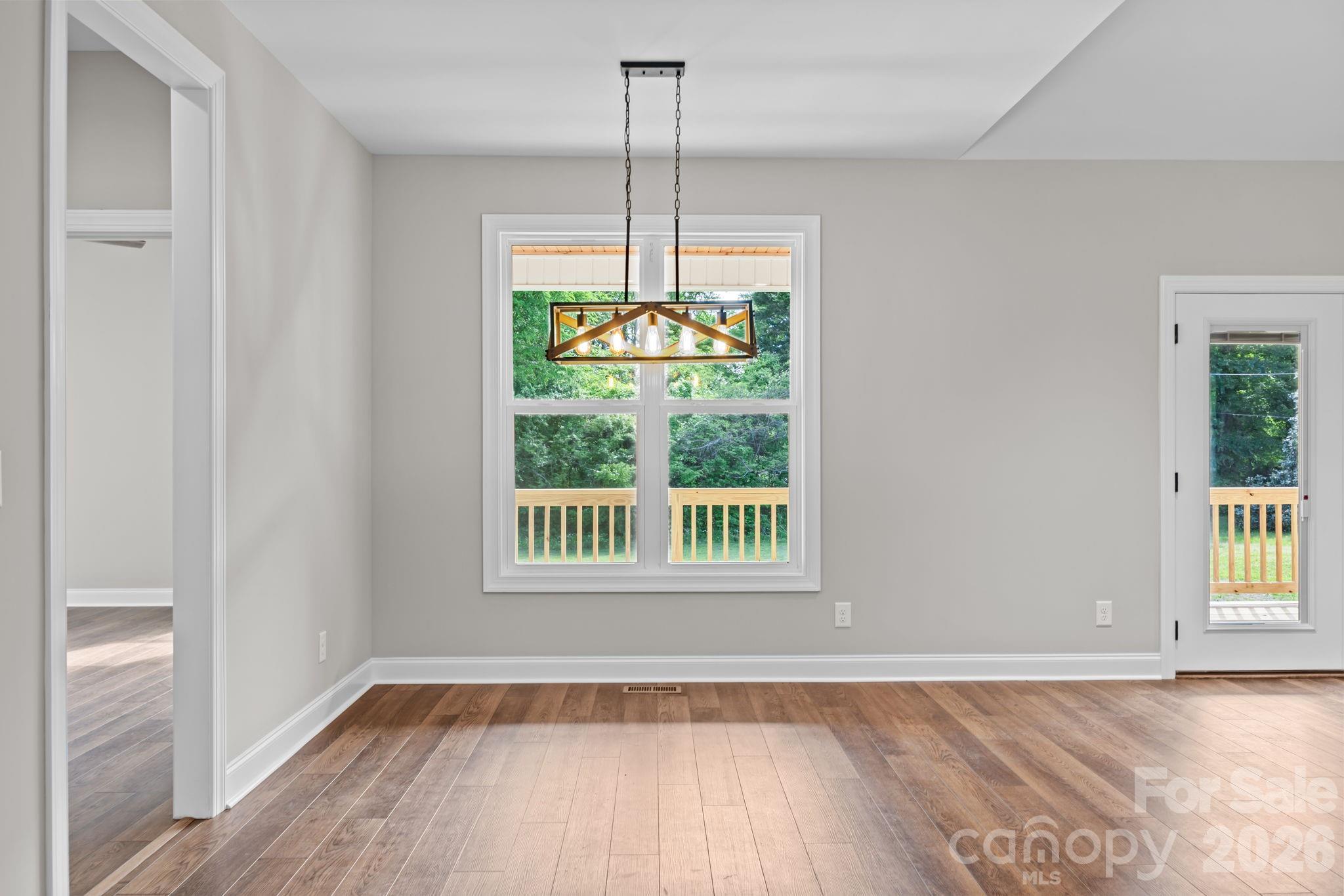 5037 Faith Road Salisbury, NC 28146 - Photo 13 of 45 a view of an empty room with wooden floor and a window