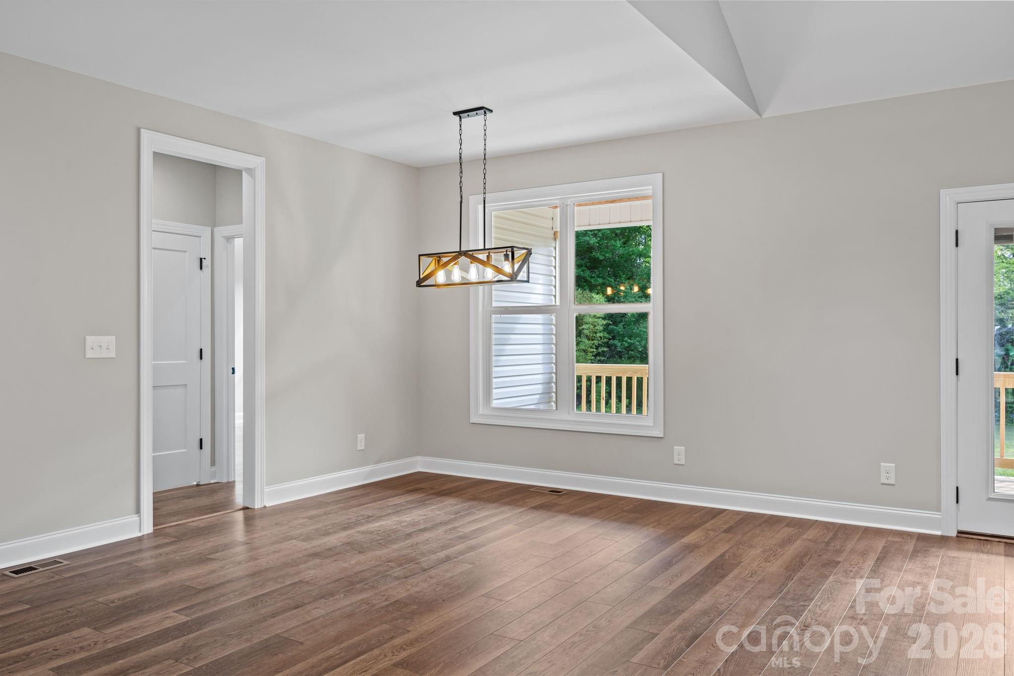 5037 Faith Road Salisbury, NC 28146 - Photo 14 of 45 a view of an empty room with wooden floor fridge and a window