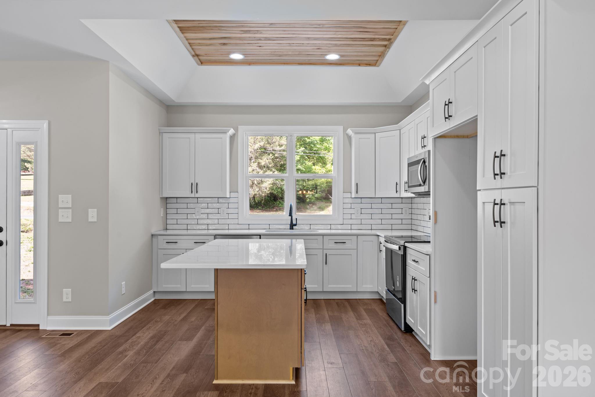 5037 Faith Road Salisbury, NC 28146 - Photo 17 of 45 a kitchen with stainless steel appliances granite countertop a refrigerator a sink dishwasher a stove and white countertops with wooden floor