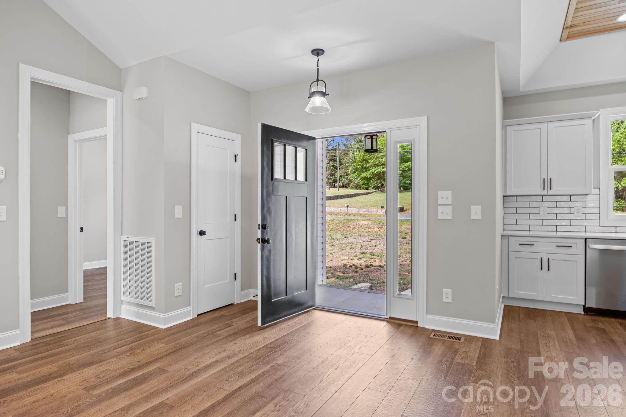 5037 Faith Road Salisbury, NC 28146 - Photo 7 of 45 an empty room with wooden floor cabinet and windows