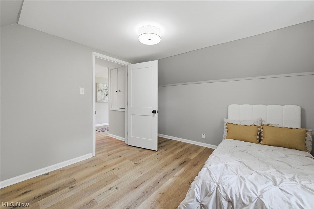 951 Bey Road Akron, OH 44312 - Photo 22 of 34 Second floor bedroom featuring wood-finish flooring, light grey painted walls, white trim, and a flush mount ceiling light fixture