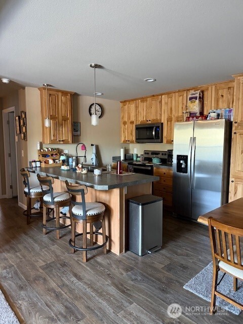 94 Grafton Road Wauconda, WA 98859 - Photo 18 of 37 a kitchen with stainless steel appliances wooden floor and chairs