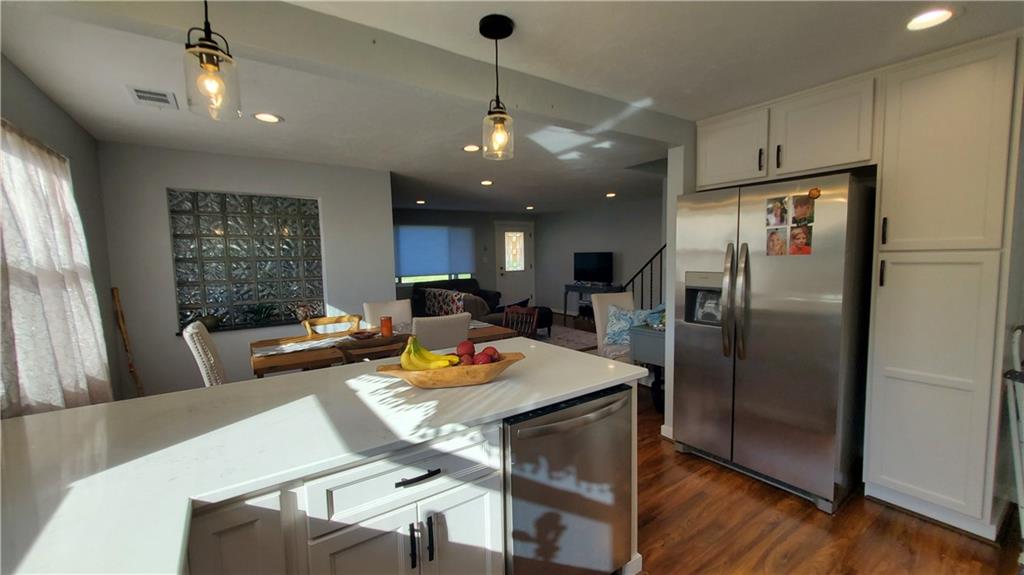 12106 Center Street Irwin, PA 15642 - Photo 13 of 27 a kitchen with stainless steel appliances granite countertop a refrigerator a sink dishwasher a dining table and chairs with wooden floor