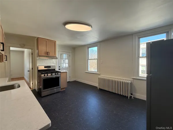 a kitchen with stainless steel appliances granite countertop a stove a refrigerator a sink a stove and a refrigerator with wooden floor