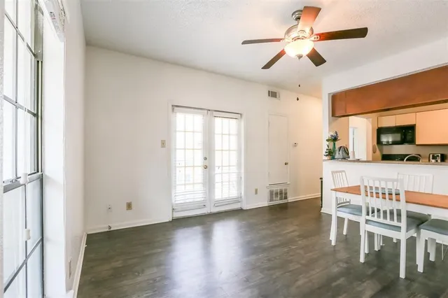 a view of an empty room with a kitchen and wooden floor