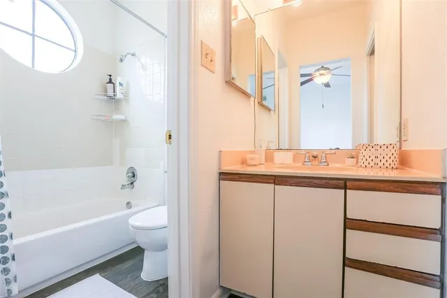 a bathroom with a granite countertop sink a toilet and bathtub