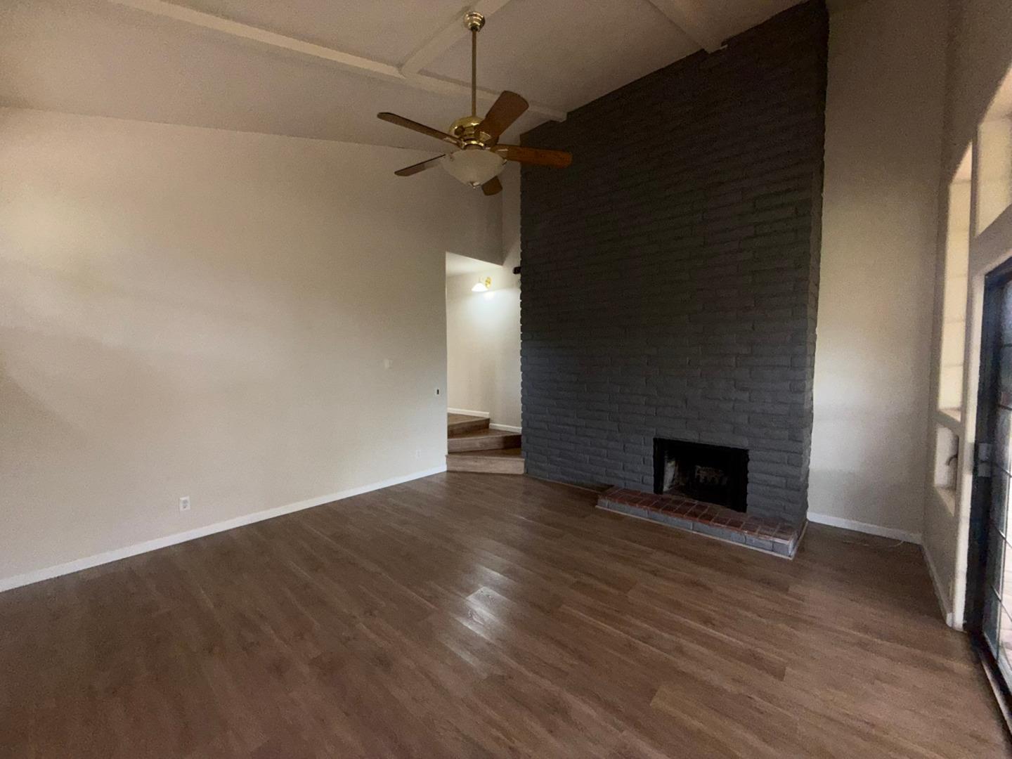 11585 McCarthy Road Carmel Valley, CA 93924 - Photo 39 of 52 an empty room with wooden floor fireplace and windows
