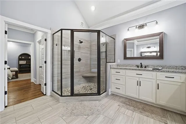 a spacious bathroom with a granite countertop sink mirror and shower