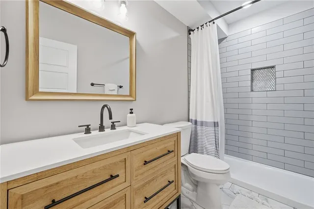 a bathroom with a sink vanity mirror and toilet
