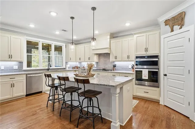 a kitchen with kitchen island granite countertop a sink cabinets and wooden floor