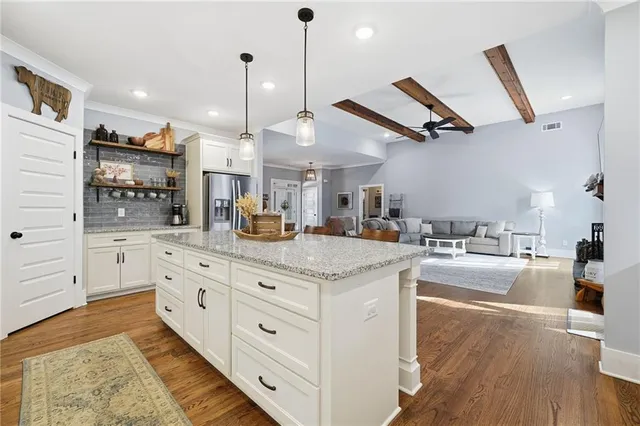 a kitchen with stainless steel appliances granite countertop a sink a stove and a wooden floors