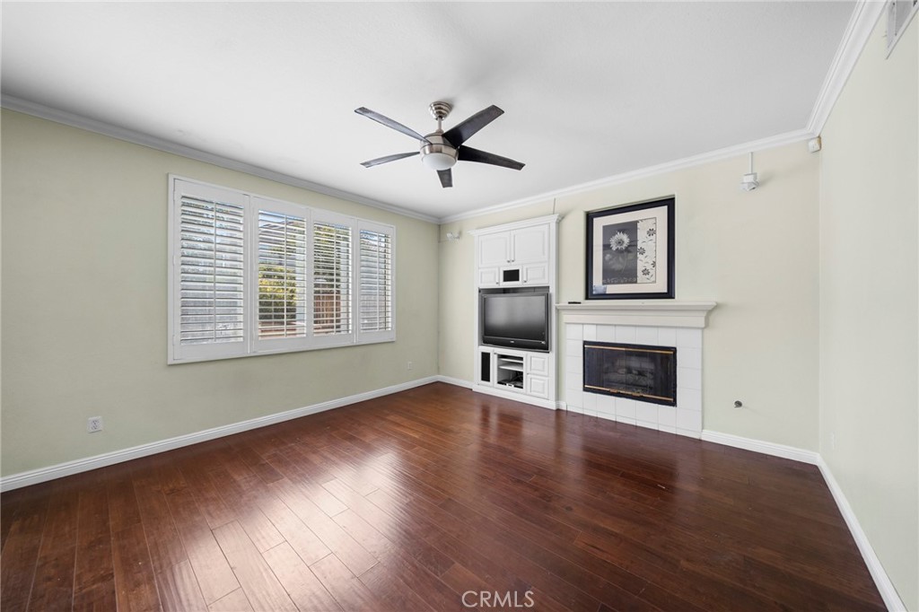 7116 Sapri Place Rancho Cucamonga, CA 91701 - Photo 25 of 52 a view of a livingroom with a ceiling fan a fireplace and wooden floor