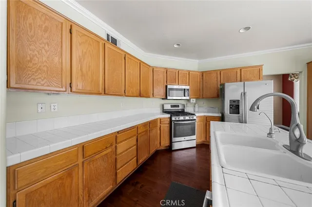 a kitchen with stainless steel appliances granite countertop a sink stove microwave and refrigerator