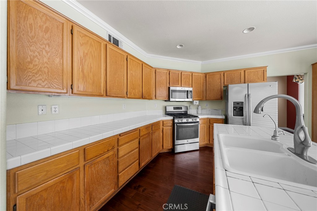 7116 Sapri Place Rancho Cucamonga, CA 91701 - Photo 29 of 52 a kitchen with stainless steel appliances granite countertop a sink stove and refrigerator