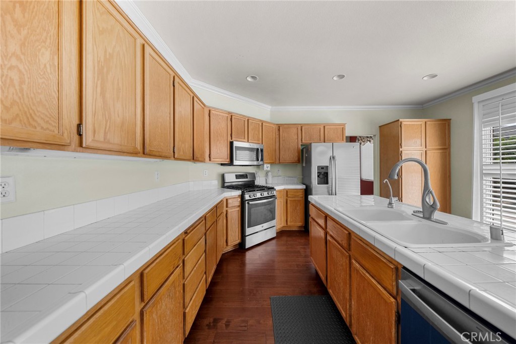 7116 Sapri Place Rancho Cucamonga, CA 91701 - Photo 30 of 52 a kitchen with stainless steel appliances sink a microwave and cabinets