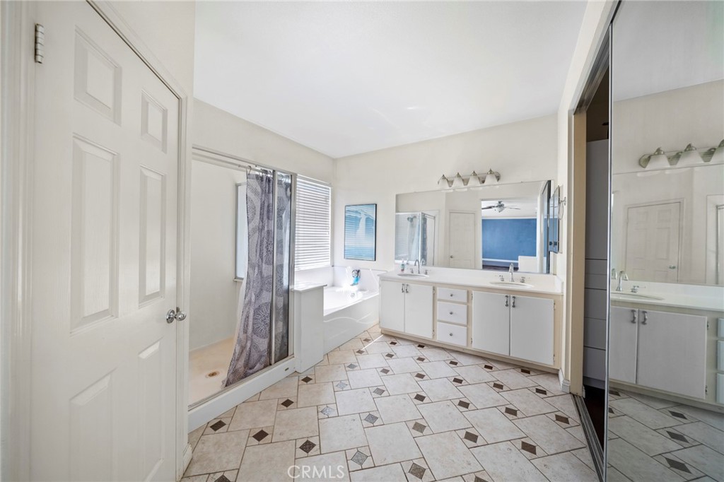 7116 Sapri Place Rancho Cucamonga, CA 91701 - Photo 38 of 52 a large white bathroom with a sink a mirror and a shower