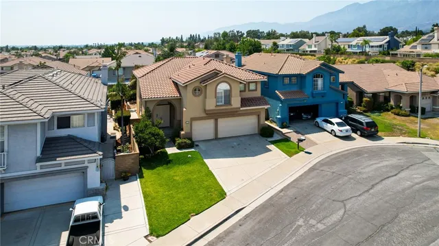 a view of a big house with a big yard and large trees