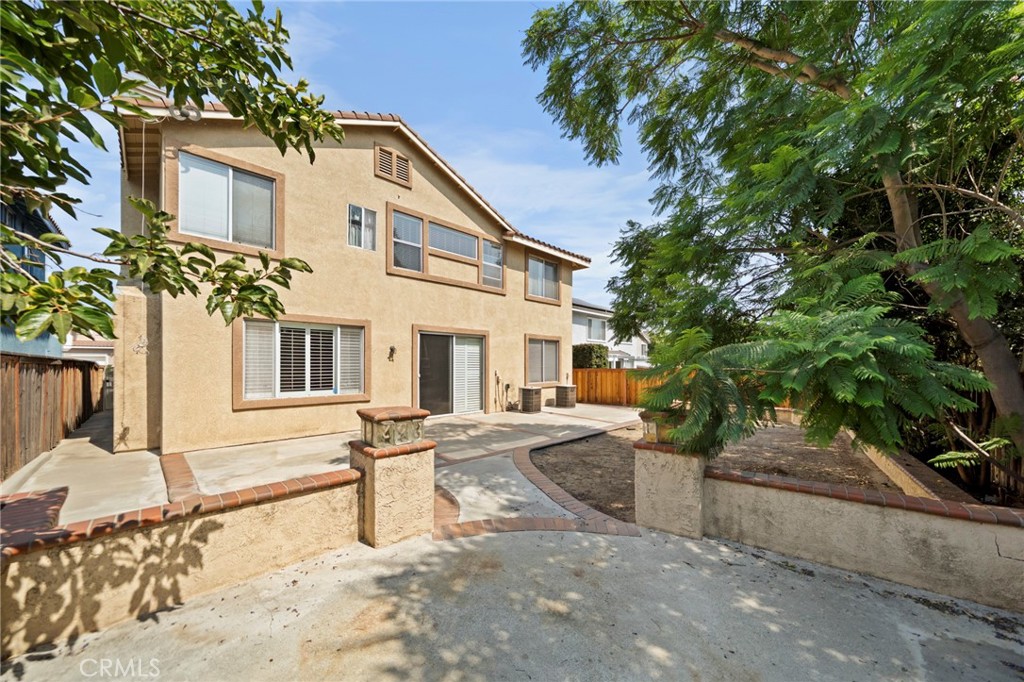 7116 Sapri Place Rancho Cucamonga, CA 91701 - Photo 51 of 52 a view of a white house with a large tree and plants