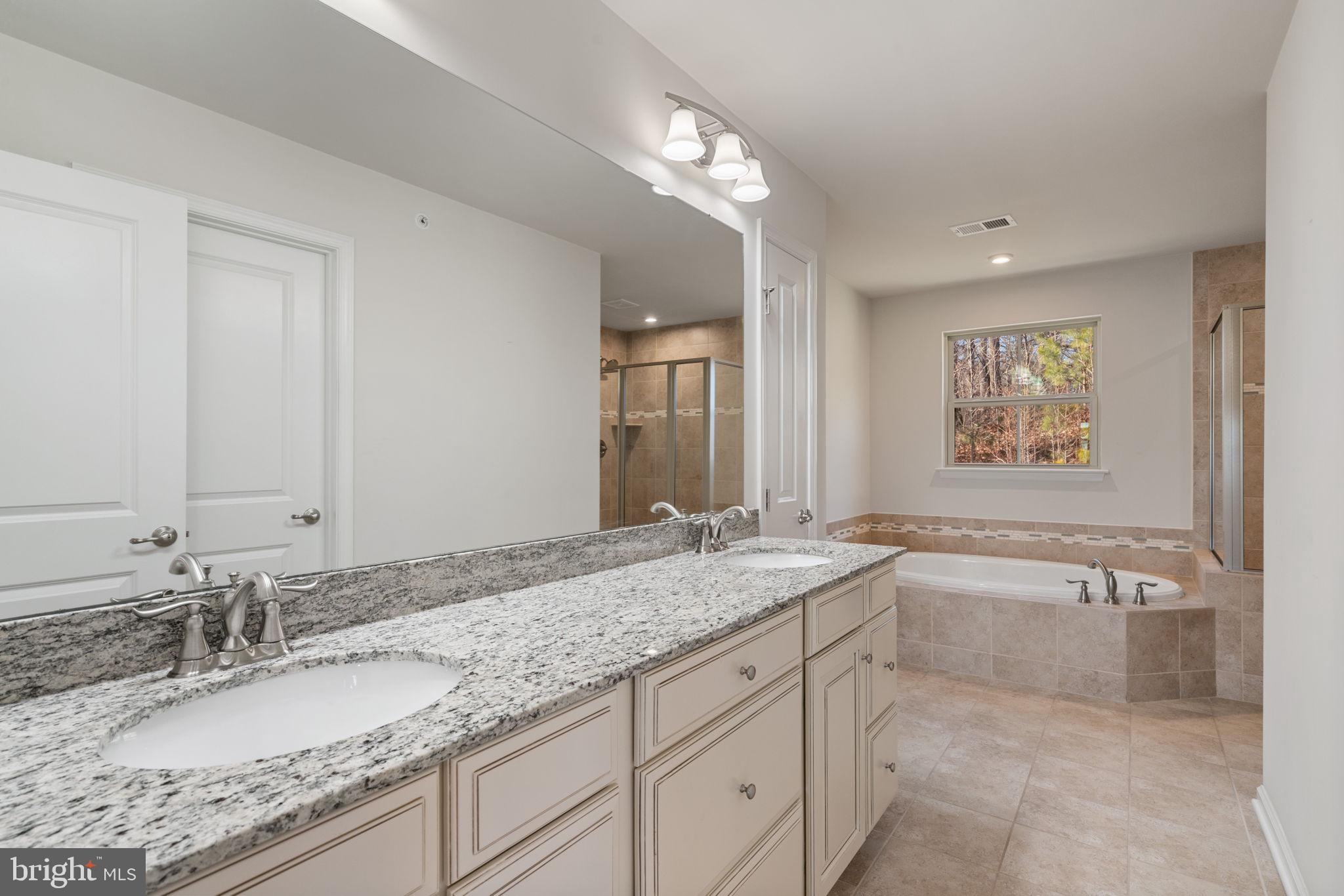 2044 Scarlet Pine Road Dumfries, VA 22026 - Photo 27 of 85 a bathroom with a granite countertop double vanity sink and a bathtub
