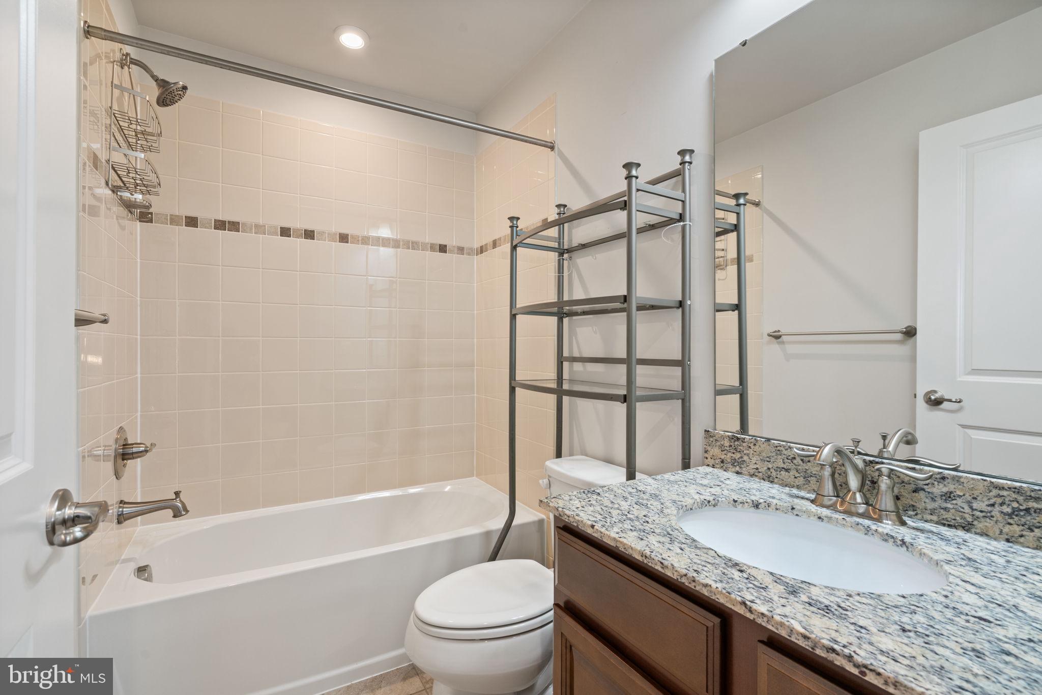 2044 Scarlet Pine Road Dumfries, VA 22026 - Photo 40 of 85 a bathroom with a granite countertop sink a toilet and shower