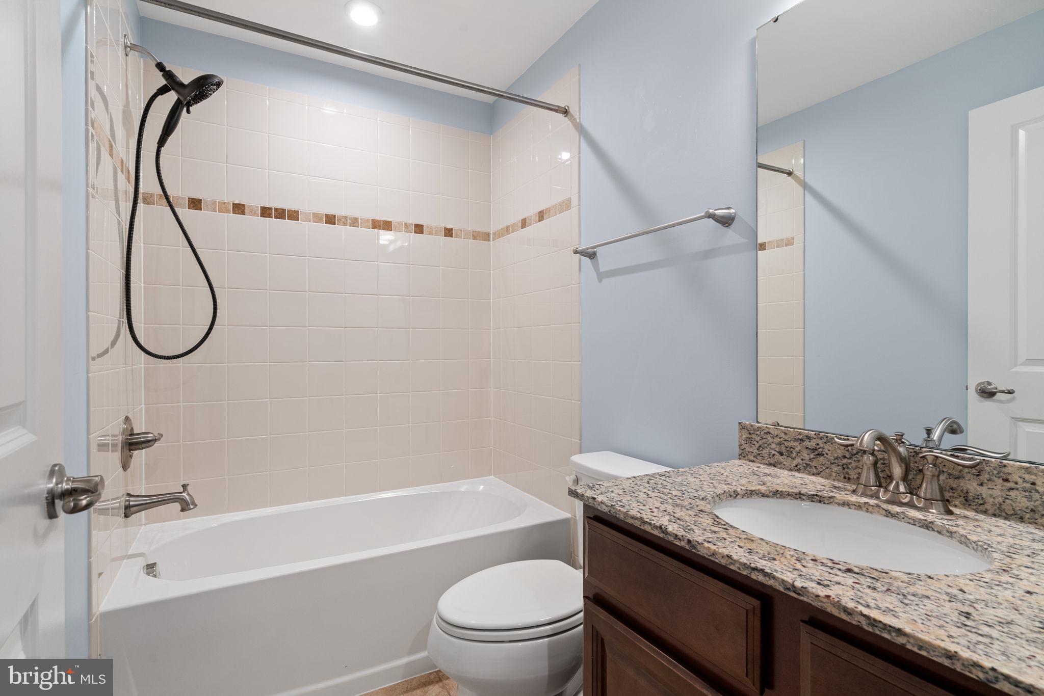 2044 Scarlet Pine Road Dumfries, VA 22026 - Photo 46 of 85 a bathroom with a granite countertop sink a toilet and a mirror