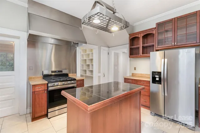 a kitchen with stainless steel appliances granite countertop a sink a stove and a refrigerator
