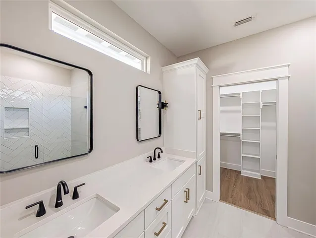 a bathroom with a double vanity sink and a mirror