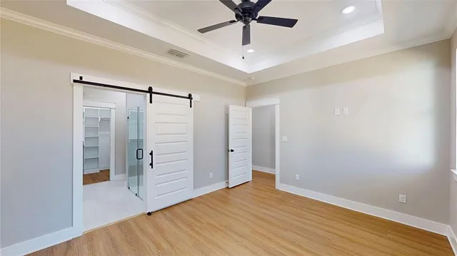 an empty room with wooden floor and ceiling fan