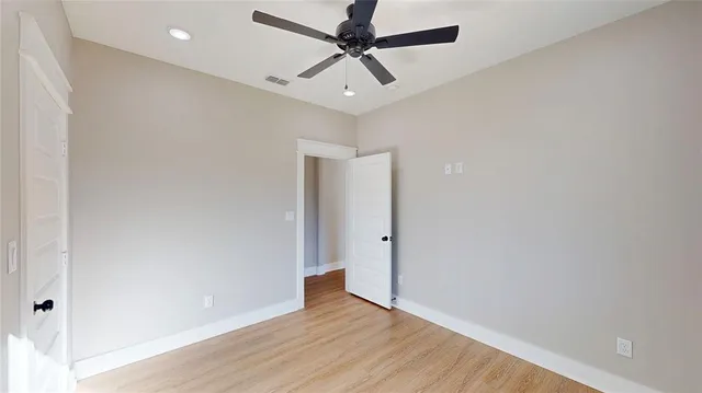 a kitchen with stainless steel appliances kitchen island a table chairs in it and wooden floors