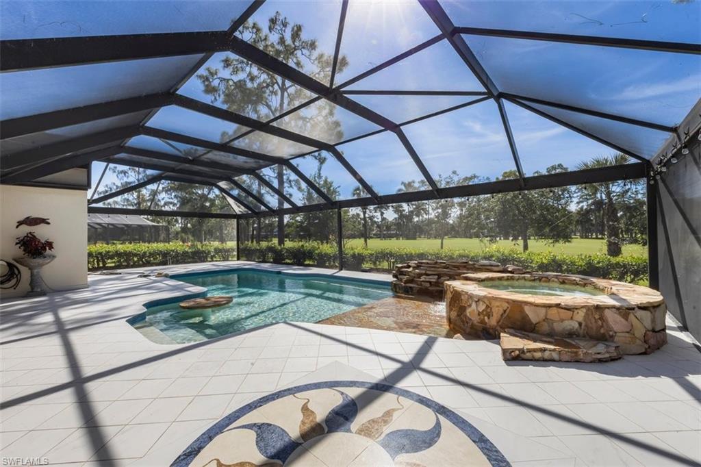 550 Cormorant Cove Naples, FL 34113 - Photo 12 of 39 a view of a patio with a table and chairs under an umbrella