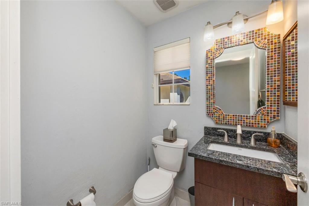550 Cormorant Cove Naples, FL 34113 - Photo 22 of 39 a bathroom with a granite countertop sink mirror vanity and toilet