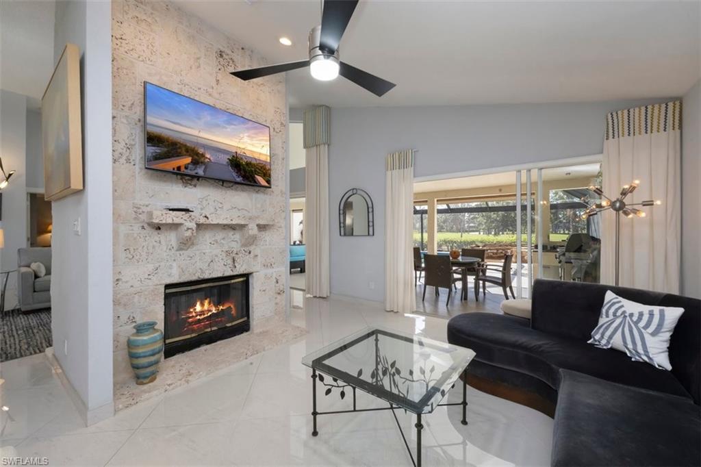 550 Cormorant Cove Naples, FL 34113 - Photo 8 of 39 a living room with furniture a flat screen tv and a fireplace
