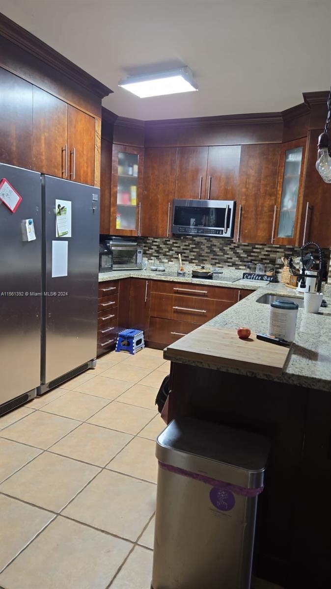 a kitchen with kitchen island a sink stove and refrigerator