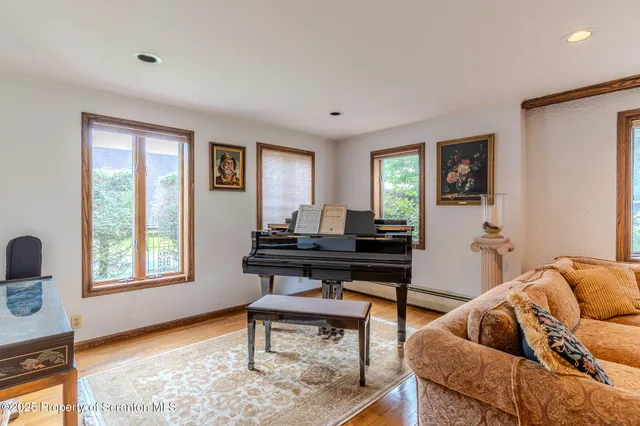 a living room with furniture and a dresser next to a window