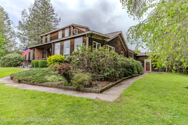an aerial view of a house with a garden and large trees