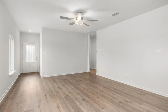 a view of an empty room with wooden floor