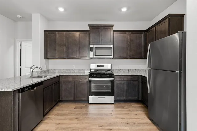 a kitchen with granite countertop stainless steel appliances and wooden cabinets