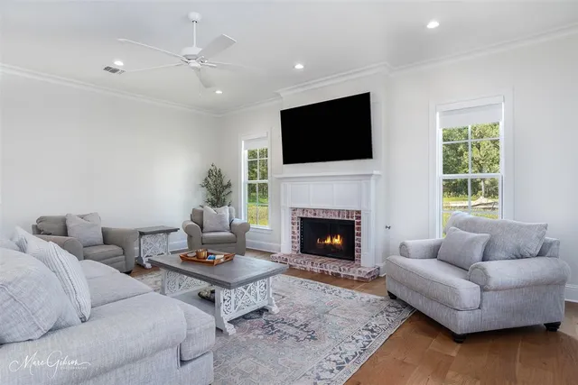a living room with furniture a flat screen tv and a fireplace