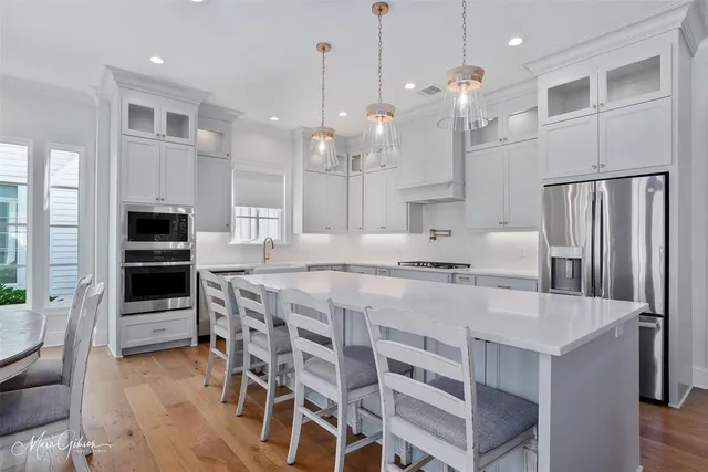 a large kitchen with kitchen island a large counter top space appliances and cabinets