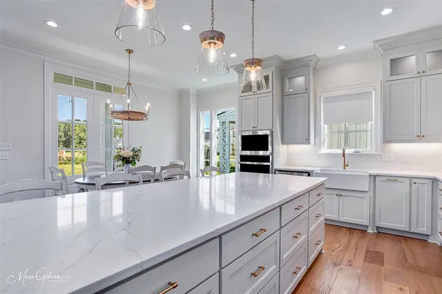 a large kitchen with kitchen island white cabinets and wooden floor