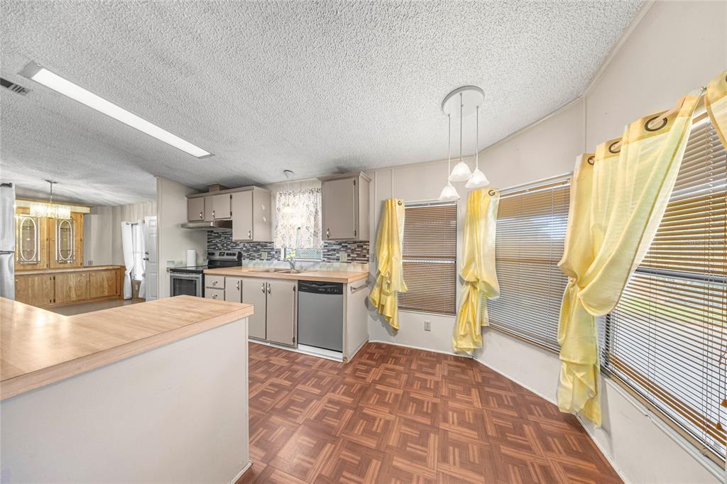 6366 Southwest 84th Lane Ocala, FL 34476 - Photo 8 of 40 a open kitchen with kitchen island white cabinets and stainless steel appliances