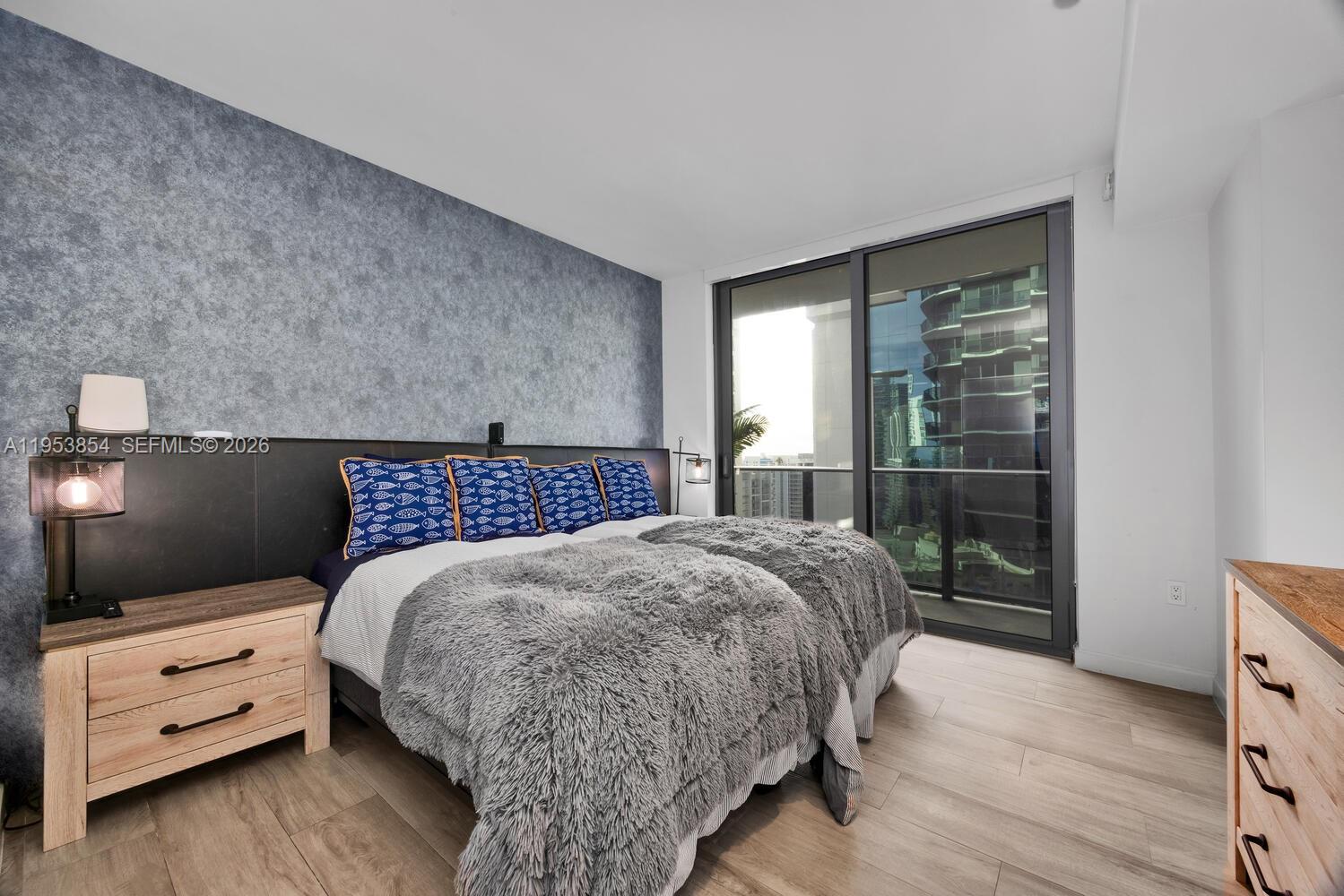 55 Southwest 9th Street, Unit 2406 Miami, FL 33130 - Photo 11 of 38 a bedroom with a bed and large window